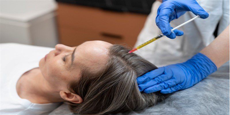 En person får en hårbehandling med spruta mot håravfall.